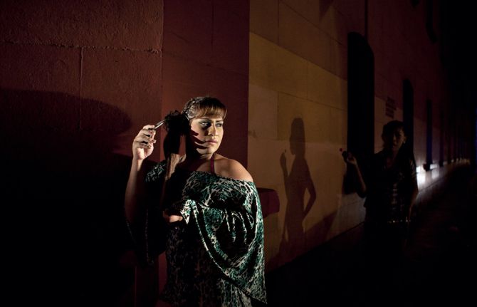 The injustices faced by transgender women in Peru: Asumi, left, and Oriana, right, stand in the light of a police car during a nightly raid. The injustices faced by transgender women in Peru: Asumi, left, and Oriana, right, stand in the light of a police car during a nightly raid.