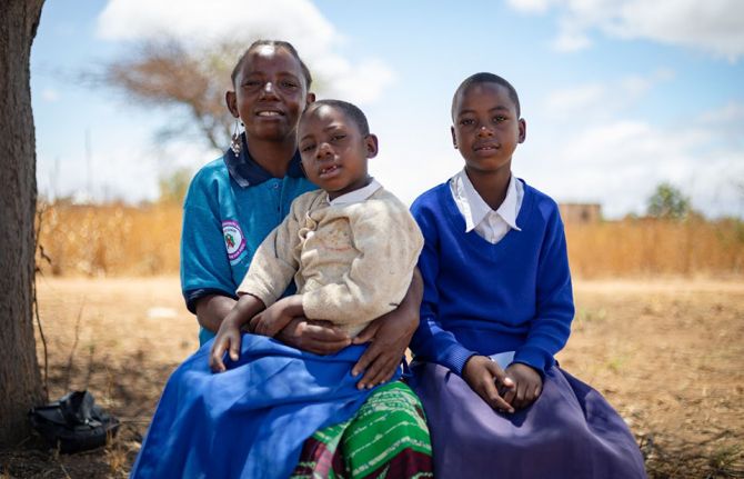 Malita Joni, a woman living with HIV, together with her children, Shuku Antoni, the youngest, and Jenifa Antoni, the eldest. Dodoma, Tanzania, 4 October 2019. Credit: UNAIDS/Daniel Msirikale Malita Joni, a woman living with HIV, together with her children, Shuku Antoni, the youngest, and Jenifa Antoni, the eldest. Dodoma, Tanzania, 4 October 2019. Credit: UNAIDS/Daniel Msirikale