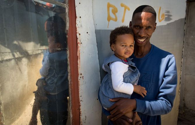 Thobani Ncapai with his daughter, Khayelitsha, Cape Town. 2017. © UNAIDS/Dwayne Senior. Thobani Ncapai with his daughter, Khayelitsha, Cape Town. 2017. © UNAIDS/Dwayne Senior.