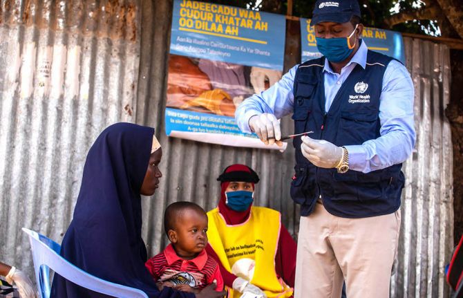 A polio zonal officer is preparing vitamin A supplement for a child during a recent integrated campaign. Photo credit: WHO Somalia A polio zonal officer is preparing vitamin A supplement for a child during a recent integrated campaign. Photo credit: WHO Somalia